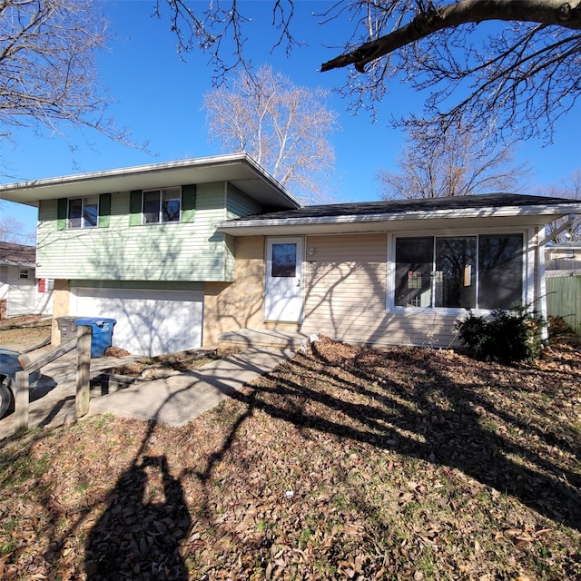 126 E Maxwelton Dr, Des Moines, IA 50315 - view of front of house with a garage, concrete driveway, fence, and a sunroom