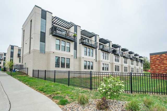 view of property featuring fence, central AC unit, and a residential view