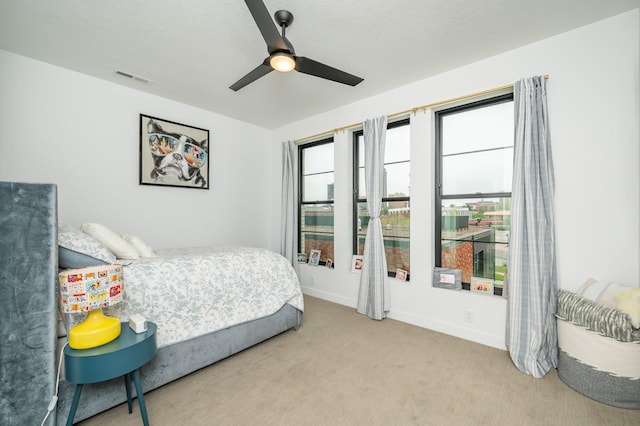 bedroom with carpet floors, a ceiling fan, baseboards, and visible vents