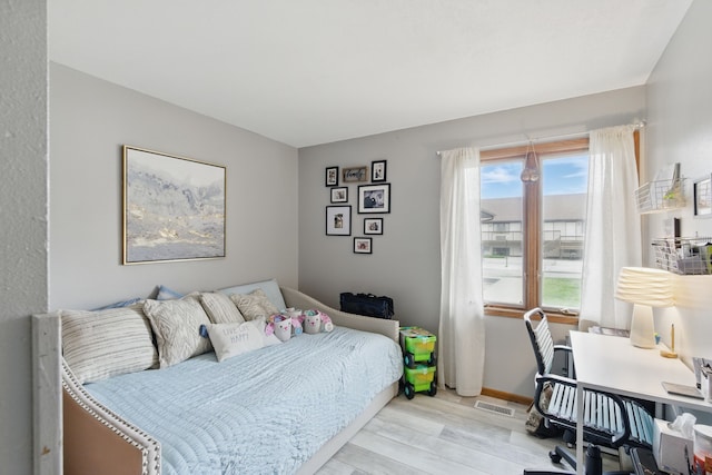 bedroom featuring visible vents and wood finished floors