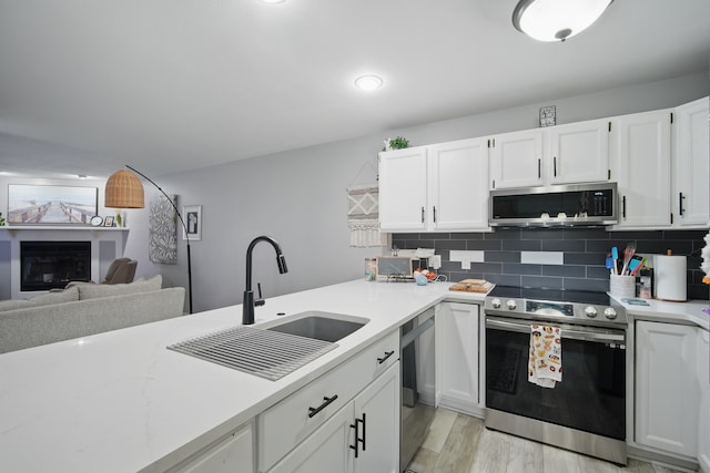 kitchen featuring a sink, white cabinetry, stainless steel appliances, and decorative backsplash