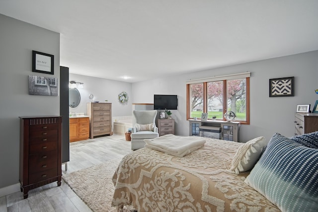 bedroom with light wood-style flooring and baseboards