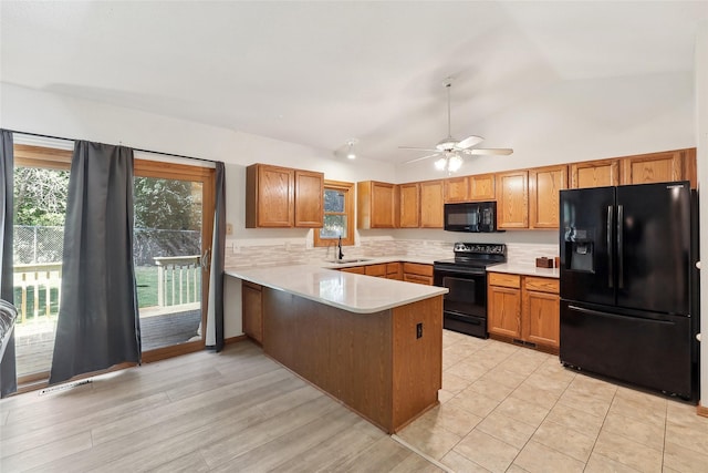 kitchen featuring light countertops, black appliances, ceiling fan, a sink, and a peninsula