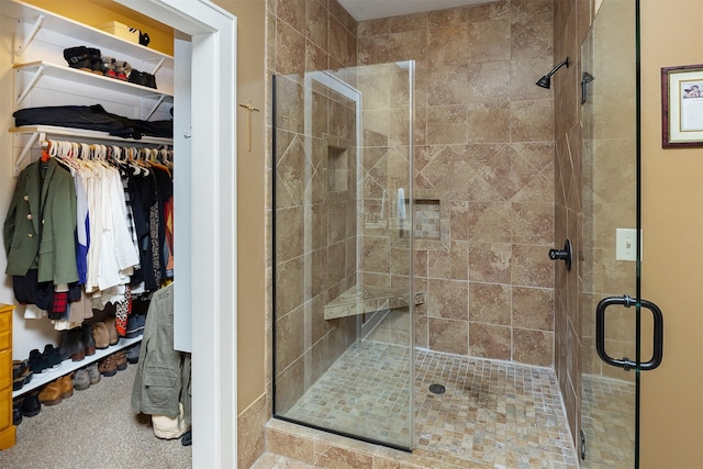bathroom featuring a spacious closet and a stall shower