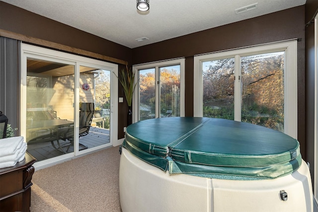 sunroom with visible vents, french doors, and a hot tub
