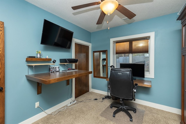 office space with a textured ceiling, a ceiling fan, light carpet, and baseboards