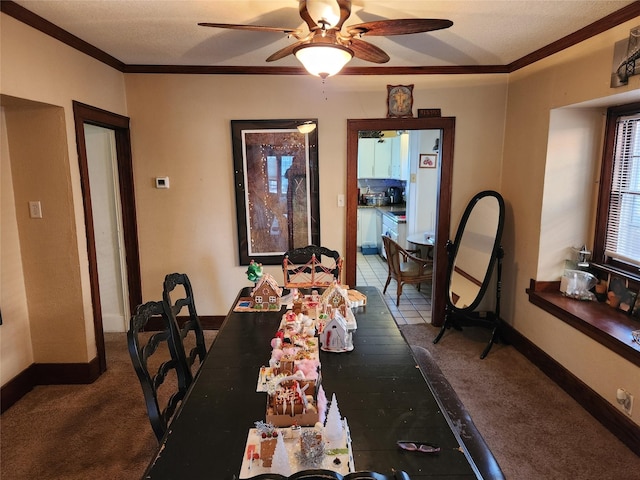 1134 39th St, Des Moines, IA 50311 - dining space featuring baseboards, dark carpet, ceiling fan, and crown molding