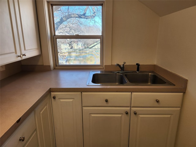 1134 39th St, Des Moines, IA 50311 - kitchen featuring white cabinetry, plenty of natural light, and a sink