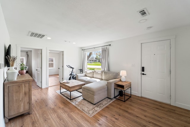 living room featuring baseboards, visible vents, and light wood-type flooring