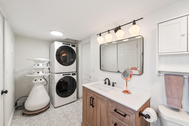 clothes washing area with stacked washer / dryer, light tile patterned flooring, a sink, and laundry area