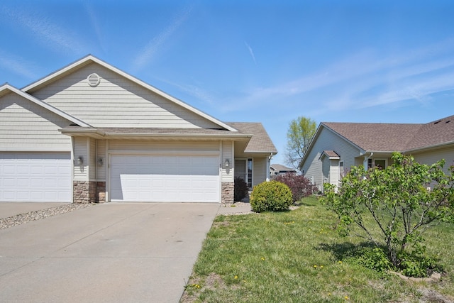 view of front of property with concrete driveway, stone siding, a garage, and a front lawn
