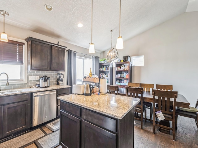 2035 SE Parkview Crossing Dr, Waukee, IA 50263 - kitchen featuring stainless steel dishwasher, a sink, dark brown cabinets, a textured ceiling, and a kitchen island