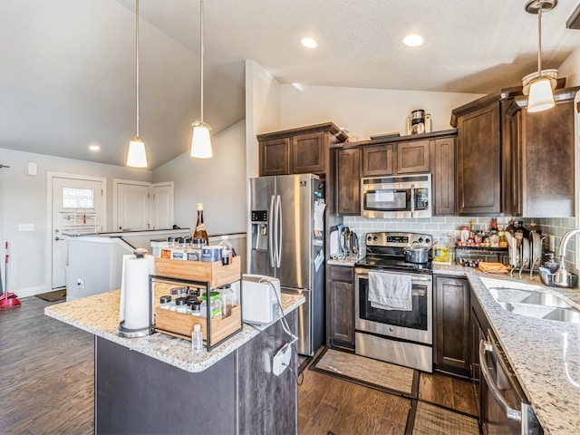 2035 SE Parkview Crossing Dr, Waukee, IA 50263 - kitchen with stainless steel appliances, a sink, vaulted ceiling, dark brown cabinets, and a center island