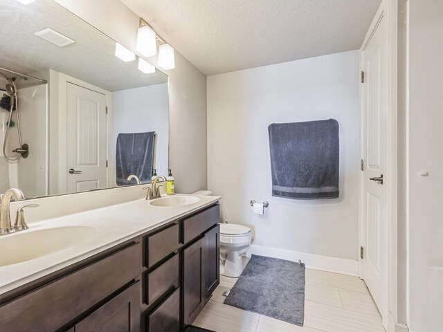 2035 SE Parkview Crossing Dr, Waukee, IA 50263 - full bathroom with toilet, baseboards, a textured ceiling, and double vanity