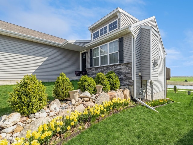 2035 SE Parkview Crossing Dr, Waukee, IA 50263 - view of side of property with a yard, stone siding, and a water view
