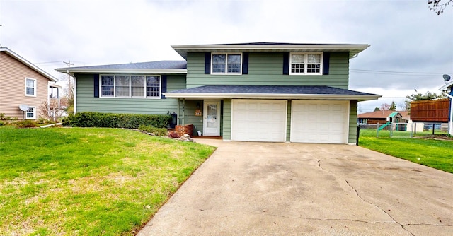 tri-level home with concrete driveway, a front yard, and an attached garage