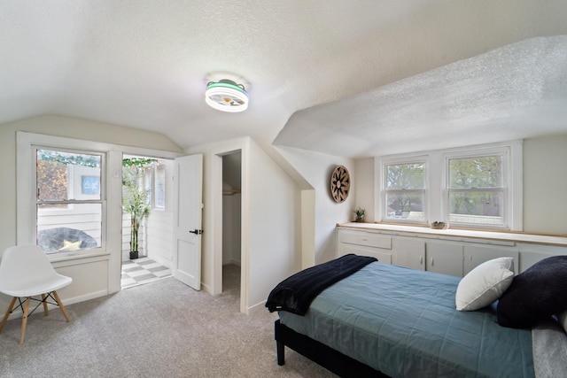 bedroom with light colored carpet, multiple windows, lofted ceiling, and a textured ceiling