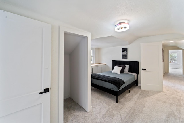 bedroom with light carpet and vaulted ceiling