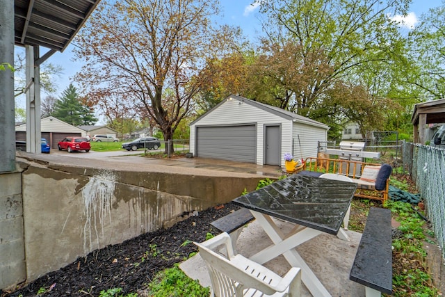 view of yard with fence, an outdoor structure, and a detached garage