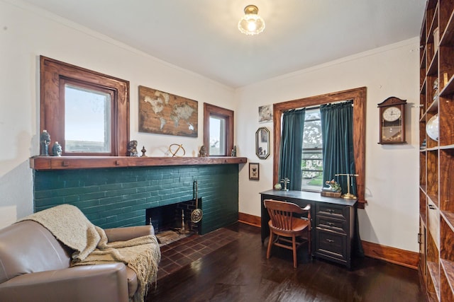 office space with baseboards, dark wood finished floors, crown molding, and a fireplace