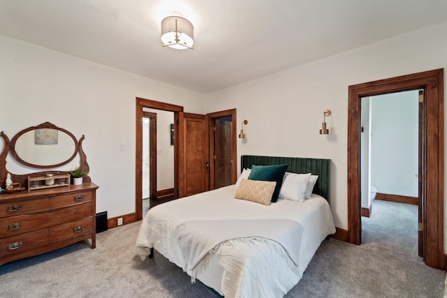 bedroom with light colored carpet and baseboards