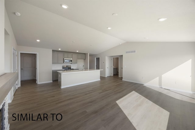 9394 Modena Ln, West Des Moines, IA 50266 - kitchen with stainless steel appliances, vaulted ceiling, gray cabinets, open floor plan, and an island with sink