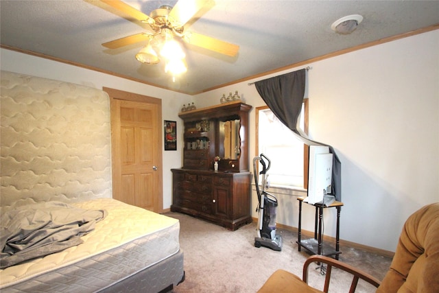 carpeted bedroom featuring crown molding, baseboards, and a ceiling fan