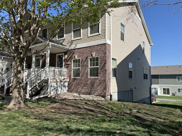 223 SE Booth Ave, Waukee, IA 50263 - exterior space featuring a yard, covered porch, and brick siding