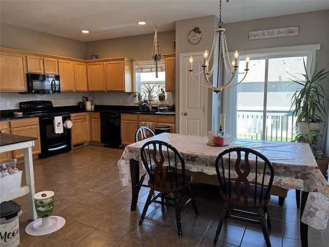 223 SE Booth Ave, Waukee, IA 50263 - kitchen with an inviting chandelier, dark tile patterned floors, black appliances, backsplash, and a sink