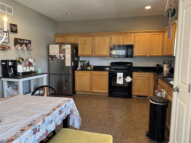 223 SE Booth Ave, Waukee, IA 50263 - kitchen with tasteful backsplash, dark tile patterned floors, black appliances, dark countertops, and visible vents