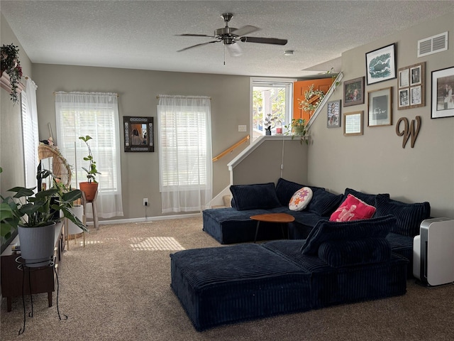 223 SE Booth Ave, Waukee, IA 50263 - living room featuring a textured ceiling, visible vents, ceiling fan, and carpet flooring