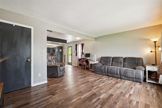 living area with baseboards and wood finished floors
