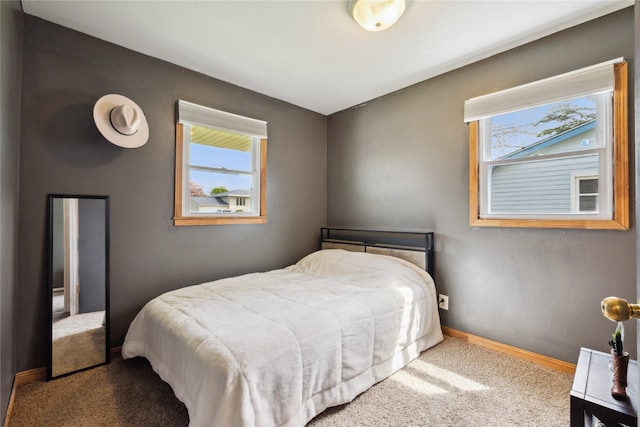 bedroom featuring multiple windows, carpet, and baseboards