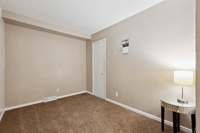 carpeted spare room featuring visible vents and baseboards