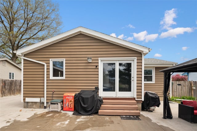 rear view of property with fence, a patio, and entry steps