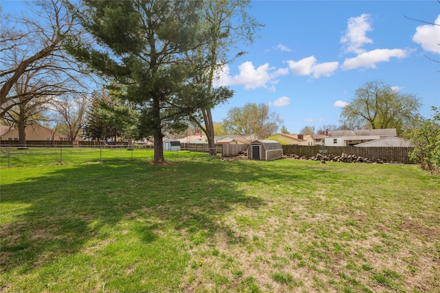 view of yard featuring a storage shed, an outdoor structure, and a fenced backyard