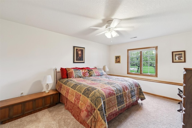 carpeted bedroom with baseboards, visible vents, and a ceiling fan
