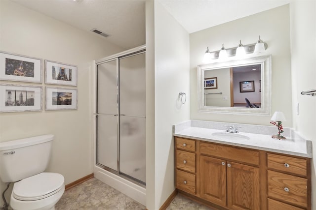 bathroom with a shower stall, toilet, vanity, baseboards, and visible vents