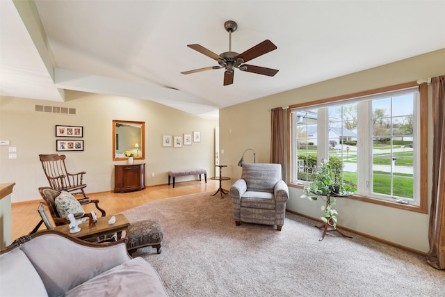 living area with visible vents, a ceiling fan, vaulted ceiling, and baseboards