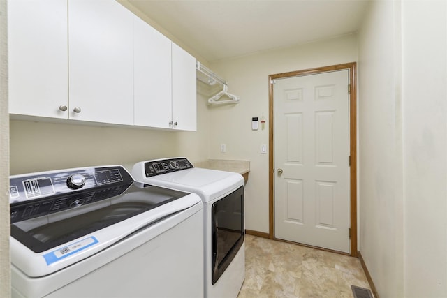 washroom with baseboards, visible vents, separate washer and dryer, and cabinet space