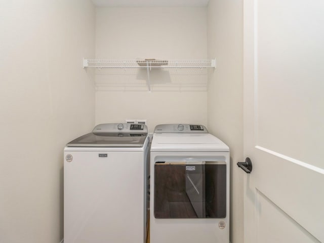 clothes washing area featuring washer and dryer and laundry area