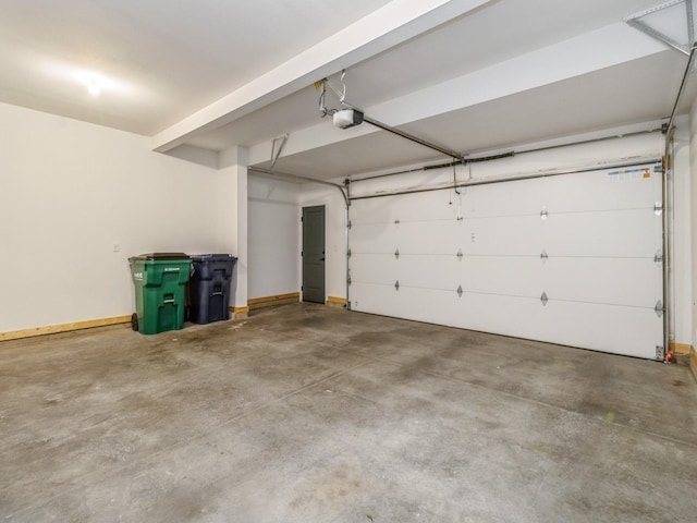 garage featuring a garage door opener and baseboards