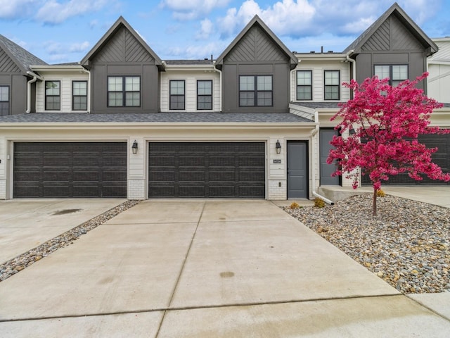 townhome / multi-family property with driveway, a garage, and board and batten siding