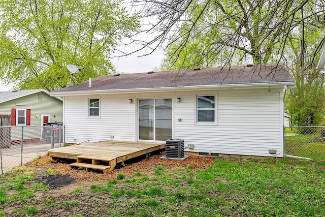 back of property featuring roof with shingles, a lawn, a wooden deck, central air condition unit, and fence