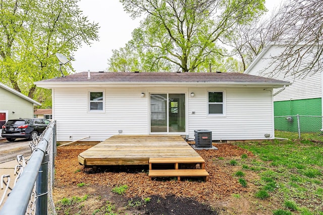 rear view of property featuring central air condition unit, fence, and a deck