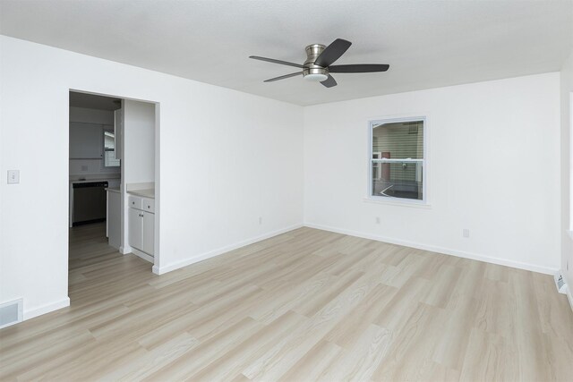 empty room with baseboards, a ceiling fan, and light wood finished floors