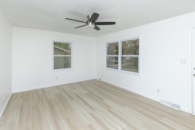 empty room featuring a ceiling fan, visible vents, and light wood-type flooring