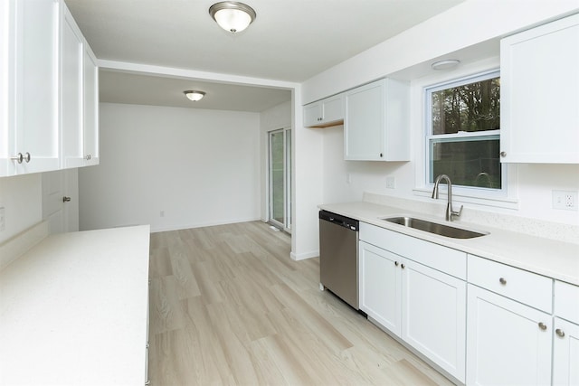 kitchen with a sink, white cabinetry, dishwasher, and light countertops