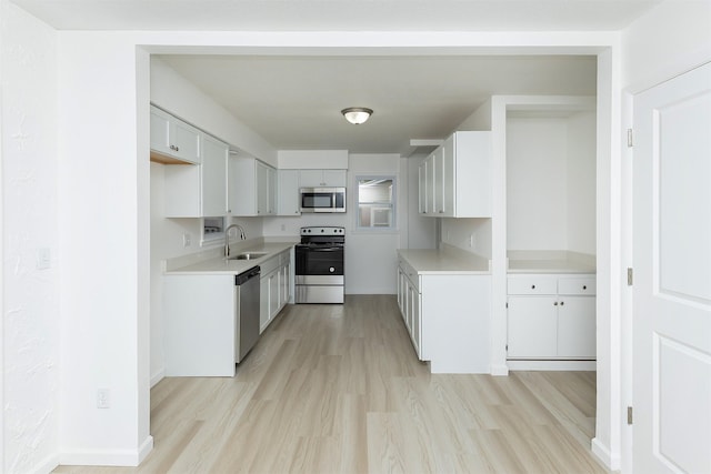 kitchen featuring a sink, light wood-style flooring, and appliances with stainless steel finishes