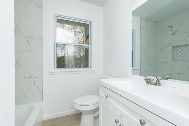 bathroom featuring vanity, baseboards, toilet, and a washtub